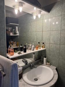 une salle de bain avec un lavabo et un miroir dans l'établissement Joli appartement avec vue sur la Tour Eiffel, à Villejuif
