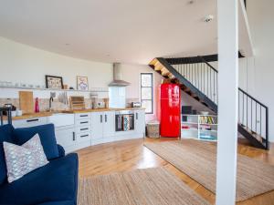 a living room with a blue couch and a red refrigerator at The Silo in Chipping Norton