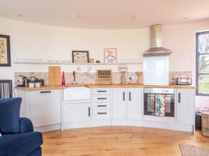 a kitchen with white cabinets and a blue chair at The Silo in Chipping Norton
