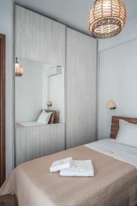 a bedroom with a bed with two towels on it at Epithea Suites Kythnos 2 με ιδιωτικη πισινα in Kithnos +17 photos