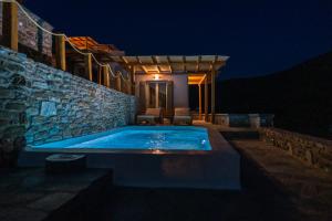 a swimming pool on the side of a house at night at Epithea Suites Kythnos 2 με ιδιωτικη πισινα in Kithnos