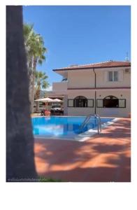 un edificio con piscina frente a una casa en Villa Laura Residence Hotel Apartments & Studios, en Ascea