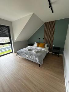 1 dormitorio con cama y ventana grande en Apartamenty Parkowa - Kamień Śląski, en Kamień Śląski