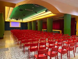 una sala conferenze con sedie rosse e schermo di Bella Italia & EFA Village a Forni Avoltri Altre 29 foto