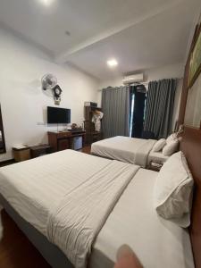 a hotel room with two beds and a television at A25 Hotel - 12 Liên Trì in Hanoi