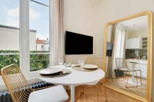 a dining room with a white table and a mirror at Suite Deluxe 2 by Les Maisons de Charloc Homes in Boulogne-Billancourt