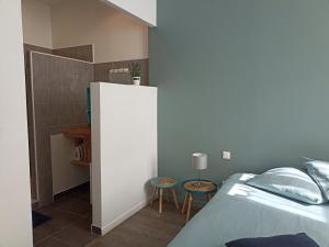 グリュイッサンにあるJolie Maison au centre du villageのベッドルーム1室(ベッド1台、スツール2台付)