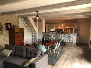 a living room with a couch and a table and a kitchen at Domaine des Annouillards in Sornac