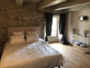 a bedroom with a large bed with a window at Domaine des Annouillards in Sornac