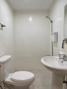 een witte badkamer met een toilet en een wastafel bij hoho house - double twin room in Busan