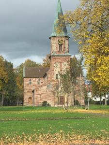 une ancienne église avec une tour d'horloge sur un champ dans l'établissement Hotel Stadt Hannover, à Rollshausen