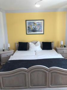 a large bed in a bedroom with two night stands at Haus Stadt Hannover am Park in Rollshausen