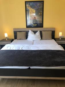 a large bed with white sheets and pillows in a bedroom at Haus Stadt Hannover am Park in Rollshausen