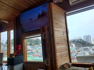 a room with a large screen tv in a room with windows at Sky Karaoke in Busan