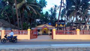 a person riding a motorcycle in front of a fence at Hotel Seaview in Murud