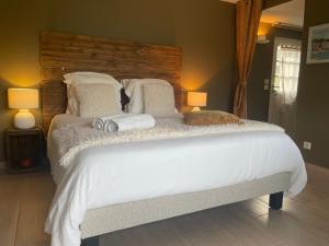 a bedroom with a large white bed with two lamps at La Pomme d'Amour in Honfleur