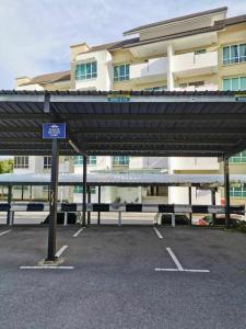 a parking lot with a canopy in front of a building at EcoPark Condo, 5mins to airport, malls & eatery in Miri