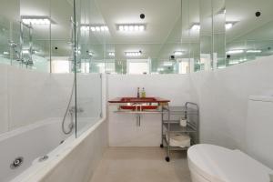a bathroom with a shower and a toilet and a sink at Fábrica da Ribeira 55 by Destination Algarve in Lagos