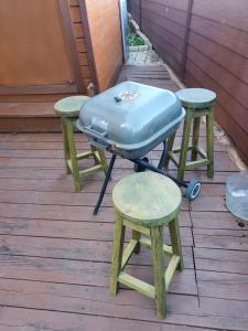 a grill and two stools on a deck at Sky Karaoke in Busan