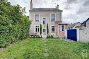 an old brick house with a blue door and a yard at Casa Simone / Bords De Loire in Tours