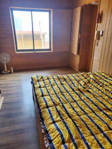ein großes Bett in einem Zimmer mit Fenster in der Unterkunft Sky Karaoke in Busan