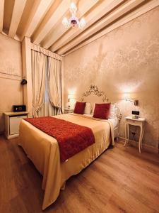 ヴェネツィアにあるホテル アルグラスポ デ ウアのベッドルーム1室(赤毛布付きの大型ベッド1台付)