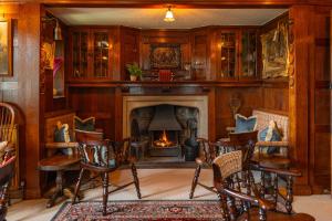 a living room with a fireplace and a table and chairs at Stone House Hotel in Hawes