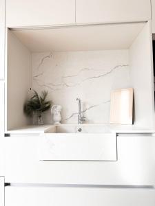 ein weißes Badezimmer mit einem Waschbecken und einem Spiegel in der Unterkunft Penthouse *A la belle étoile* in Wahlbach