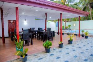 a restaurant with a table and chairs and plants at My Resort Yala in Tissamaharama