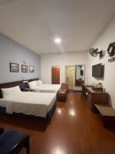 um quarto de hotel com duas camas e uma secretária em A25 Hotel - 80 Mai Hắc Đế em Hanói