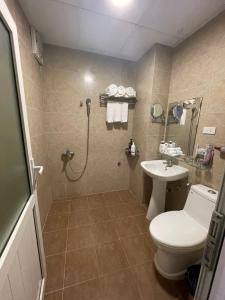 uma casa de banho com um chuveiro, um WC e um lavatório. em A25 Hotel - 80 Mai Hắc Đế em Hanói