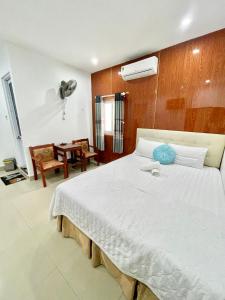 a bedroom with a large white bed with a fan at Ngọc Lan Homestay in Hue