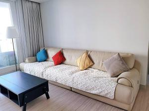 uma sala de estar com um sofá com almofadas em Emotion-고층뷰, 3룸, 화2 신축, 건조기, 세탁기, 이마트2분, 별내역3분, 출장 및 장기숙박 추천 em Namyangju