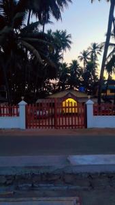 a house with a fence and palm trees behind it at Hotel Seaview in Murud