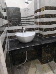 a bathroom with a white sink on a black counter at Sky Inn paying guest house in Varanasi