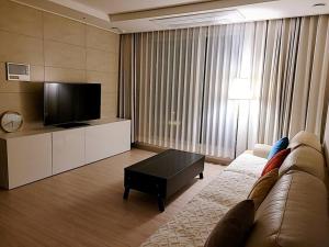 uma sala de estar com um sofá e uma TV de tela plana em Emotion-고층뷰, 3룸, 화2 신축, 건조기, 세탁기, 이마트2분, 별내역3분, 출장 및 장기숙박 추천 em Namyangju