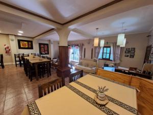 a dining room with tables and chairs and a kitchen at Hostería Austral in El Calafate