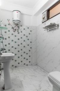 a white bathroom with a sink and a toilet at Mountain Crest Kasauli I 2 Bhk Service Apartment I Kasauli in Kasauli