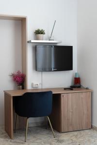 a desk with a television on a wall with a chair at B&B Longobardi in Trani