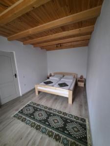 1 dormitorio con 1 cama en una habitación con alfombra en Zöld Tulipán, en Praid