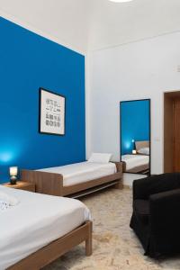 Habitación con 2 camas y pared azul en B&B Longobardi, en Trani