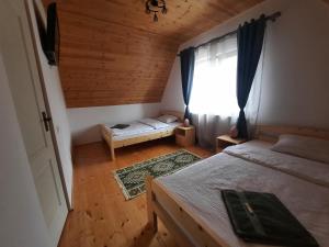 a small bedroom with two beds and a window at Zöld Tulipán in Praid