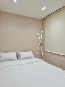een slaapkamer met een wit bed en een raam bij hoho house - double twin room in Busan