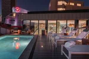 a swimming pool with lounge chairs next to a building at Vincci Bonjardim in Porto
