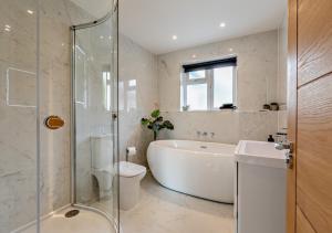 a bathroom with a tub and a toilet and a sink at Greenacres in Chittlehampton