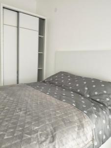 a bedroom with a bed with a gray comforter at Tivat Apartman in Tivat