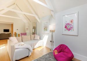 a white living room with a couch and a chair at The Barn at Lower Longcombe in Stoke Gabriel