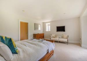 a white bedroom with a bed and a couch at The Barn at Lower Longcombe in Stoke Gabriel