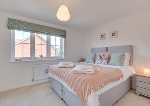 a bedroom with a large bed and a window at Shearwaters in Seaton