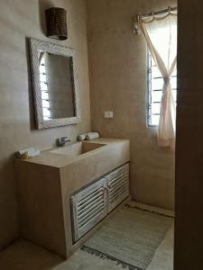 baño con lavabo, espejo y ventana en Mwezi - Maisha Resort, en Watamu